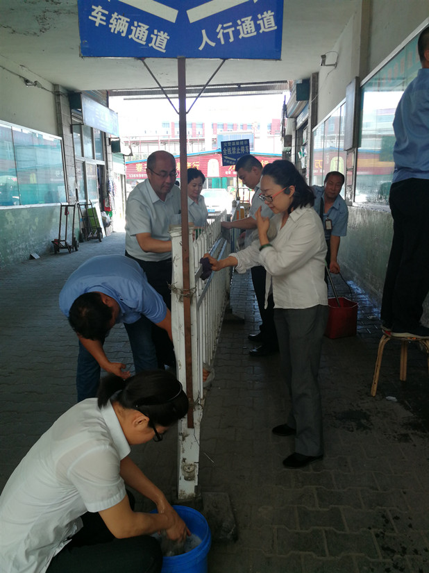 1564546249608654.jpg 圖為:農(nóng)貿(mào)市場(chǎng)管理人員在清洗欄桿_副本.jpg